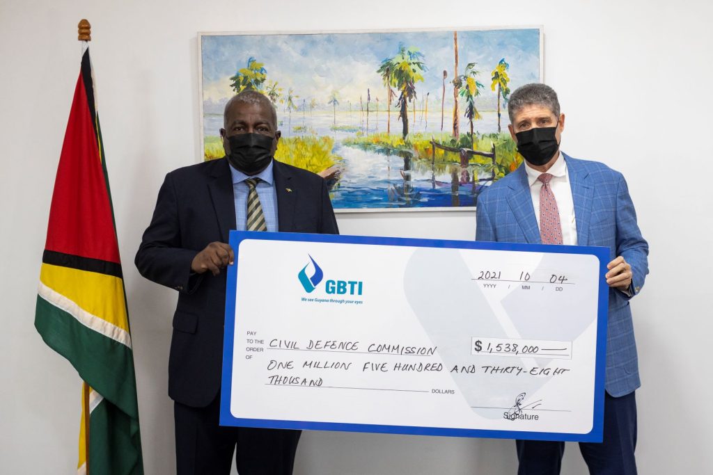 GBTI CEO (ag) James Foster presents the symbolic cheque to Prime Minister Honourable Brigadier (Ret’d) Mark Phillips